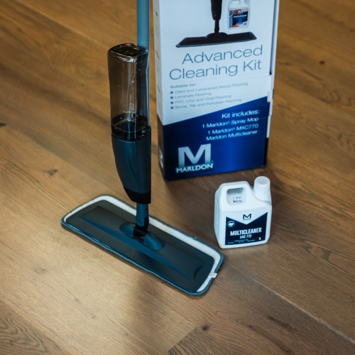 Close up shot of the Marldon spray mop, multicleaner and the box they come on a clean, dark, wooden floor